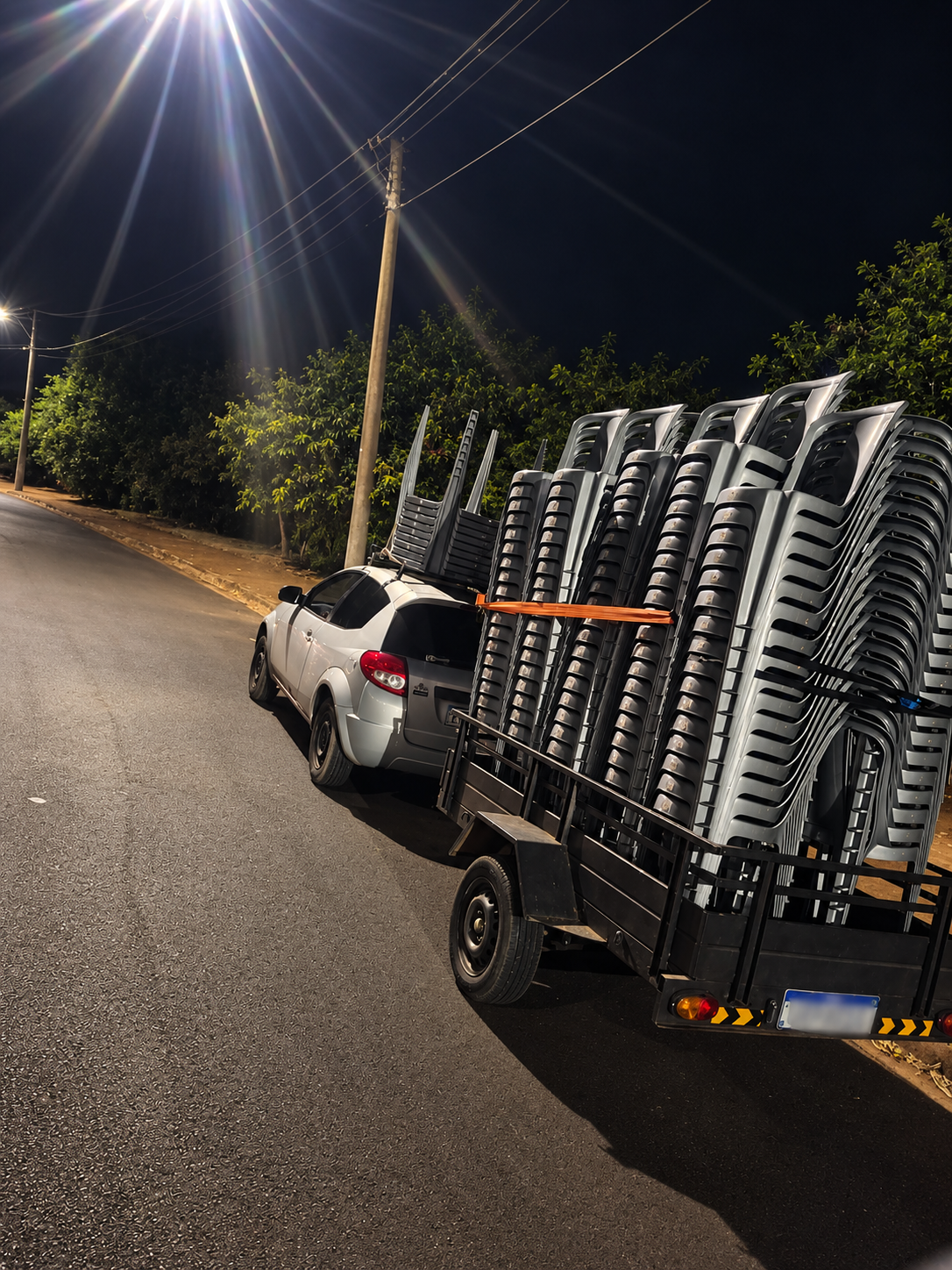 Carreta de cadeiras sob a luz noturna durante entrega